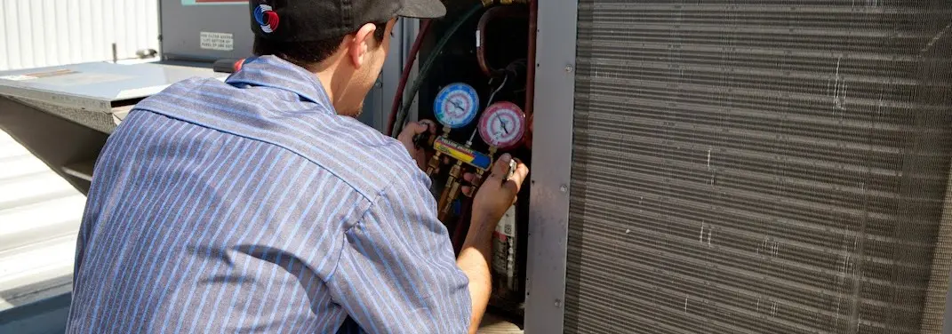 HVAC technician servicing a condenser unit in Wade Hampton